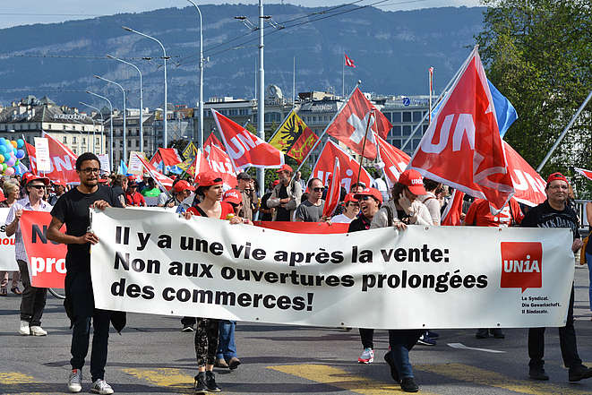 Des participant-e-s à une manifestation syndicale à Genève marchent derrière une banderole sur laquelle est inscrit "Il y a une vie après la vente. Non aux ouvertures prolongées des commerces!"