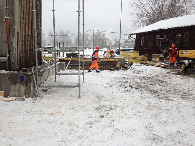 Ein Bauarbeiter auf der Baustelle im Winter mit Schnee