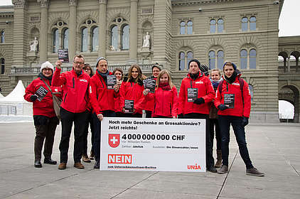 Unia-Aktivisten vor dem Bundeshaus mit einem Schild «4'000'000'000 Franken – Noch mehr Steuergeschenke für Grossaktionäre? Jetzt reichts!»