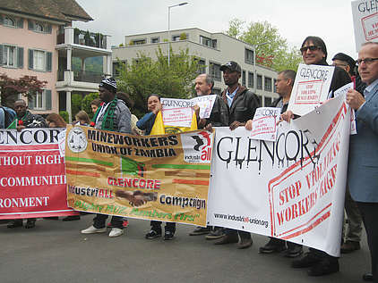 Die Protestierenden vor dem Casino in Zug mit Transparenten: Stop violating workers rights