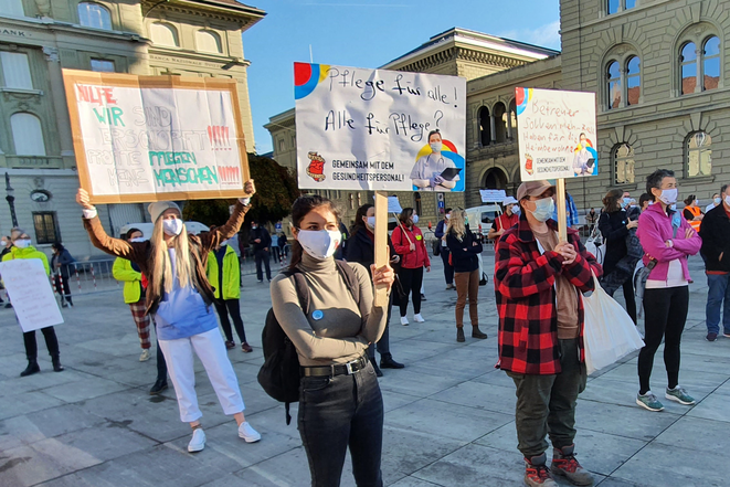 Pflegende protestieren mit Schildern auf dem Bundesplatz