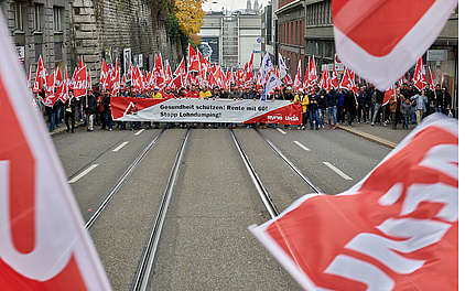 Bauarbeiter fordern an einem Umzug durch Zürich: Gesundheit schützen! Rente mit 60! Stopp Lohndumping!