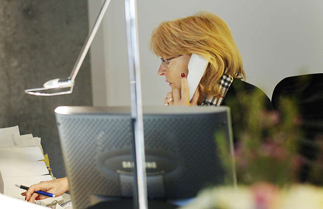 Büroangestellte hinter Bildschirm am Telefon
