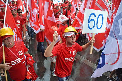 Bauarbeiter an Demo mit einem grossen Schild «60»