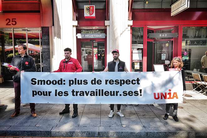 Employé-e-s Smood et Unia avec une banderole: "Plus de respect pour les travailleur-euses"