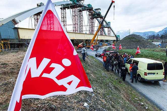 Des secrétaires syndicaux (avec des vestes rouges d'Unia) sur un chantier d'un pont en construction