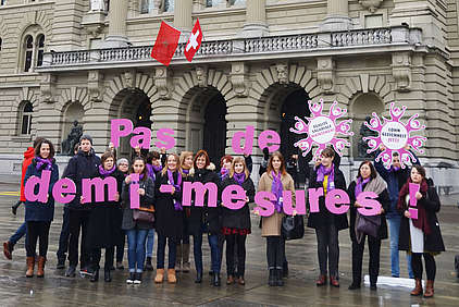 «Pas de demi-mesures» – Frauen mit lila Buchstaben vor dem Bundeshaus