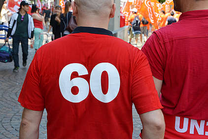 Homme de dos avec "60" blanc sur T-shirt rouge.