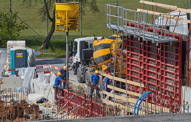 Quatre travailleurs de la construction en train d’effectuer des travaux de coffrage sur un chantier.