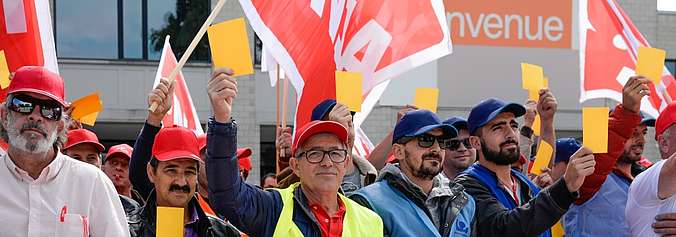 Des travailleurs du second œuvre romand brandissent des cartons jaunes devant les bureaux de la Fédération vaudoise des entrepreneurs