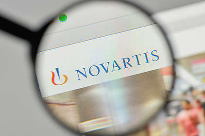 Le logo de Novartis à travers une loupe
