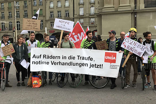 Les employés du service de livraison à vélo Notime protestent sur la Place de la Gare à Berne contre la violation de leurs droits.