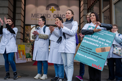 Waadtländer Pharmaasstistentinnen an in weisser Schütze mit Plakat: Une CCT pour les assistent-e-s en pharmacie! 