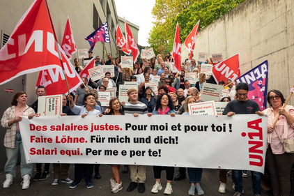 Des membres d'Unia chez Coop avec une banderole: "Des salaires justes. Pour toi et pour moi!"