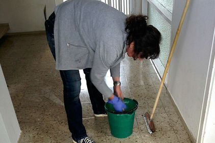Una donna pulisce il pavimento 