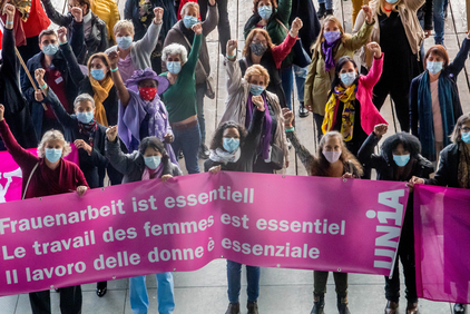 Déléguées avec une banderole en rose: Le travail des femmes est essentiel
