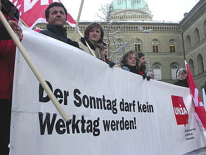 Demonstration gegen Sonntagsarbeit mit Transparent und Unia-Fahne