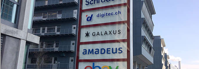 Firmenlogos vor modernem Gebäude inkl. Galaxus und Digitec