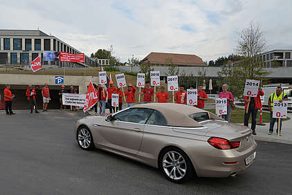 Des syndicalistes d’Unia avec tracts et banderoles au bord d’une route.