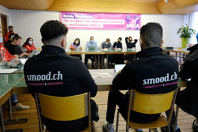 Rückenansicht zweier Smood-Kuriere an der Unia-Medienkonferenz in zu ihren prekären Arbeitsbedingungen
