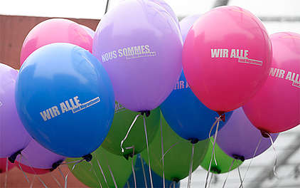 Ballone mit dem Schriftzug «Wir alle sind Migrant*innen»