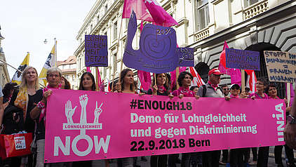Menschen mit Schildern und Transparenten an der Demo für Lohngleichheit in Bern